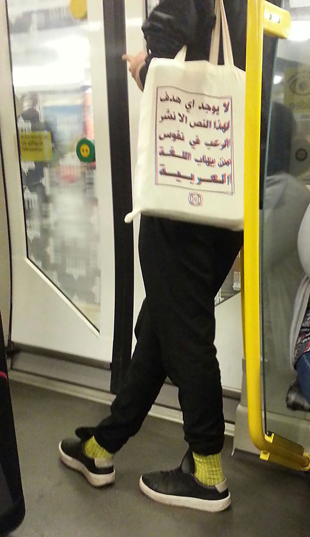 Enquanto isso, em um metrô de Berlim. O texto no saco lê: "Este texto não possui outra finalidade do que aterrorizar aqueles que estão com medo da língua árabe".