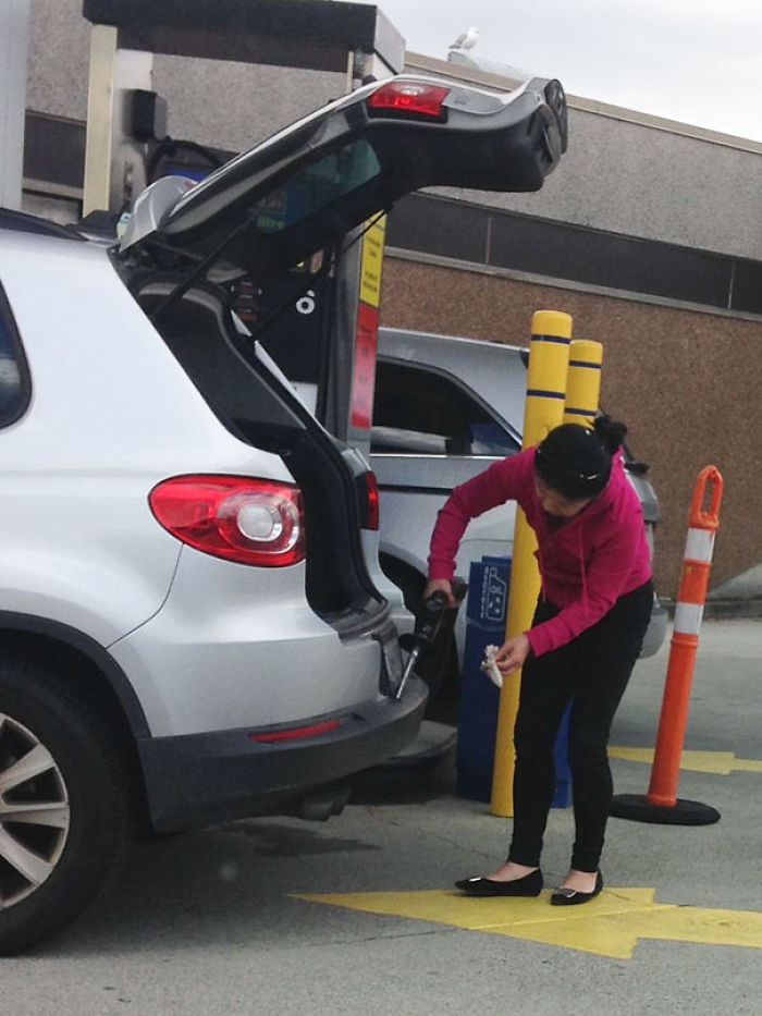 Woman At Station Using Gasoline To Clean Bumper