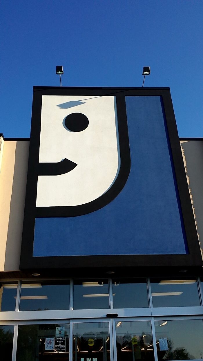 Shadow On Goodwill Sign Makes The Face Appear Menacing