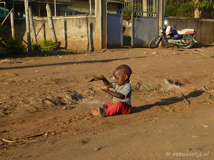 Uganda, Boy Playing With Sand.
