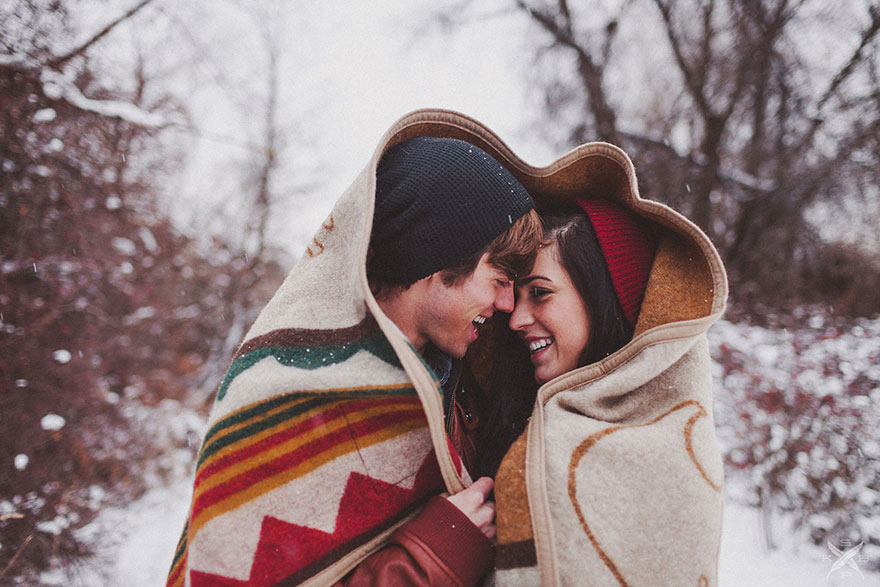 the pair covering in a blanket standing in a snowy yard