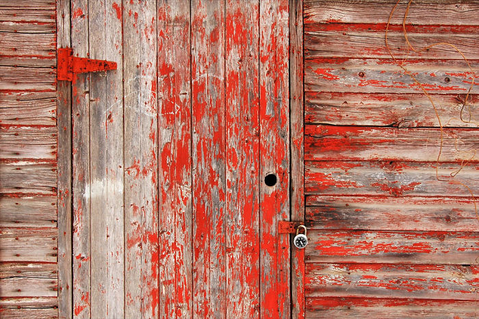 A Faded Red Locked Door In A Toronto Laneway