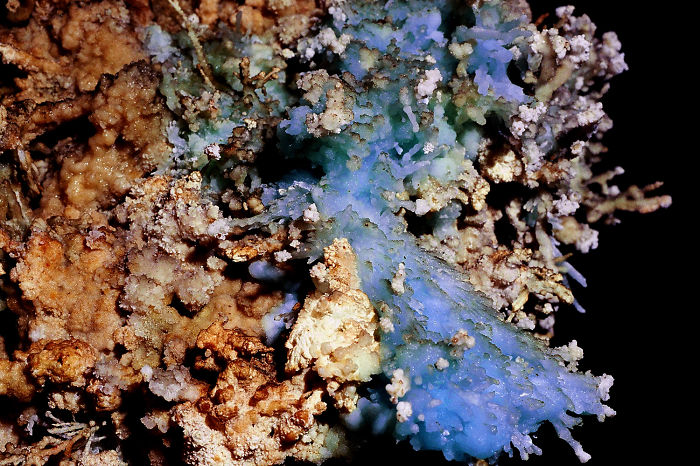 Close-up of beautiful cave formations showcasing intricate blue and brown mineral deposits in a natural underground setting