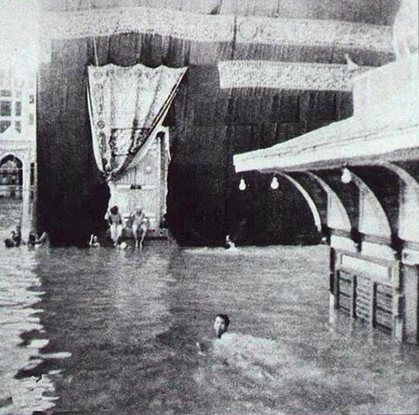 People Swimming Around The Kaaba, The Holy Place Of The Muslims, After A Heavy Rain.
