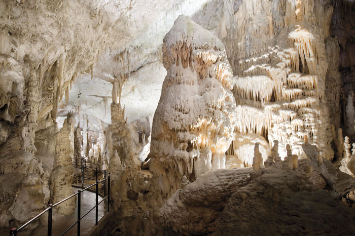 Beautiful caves with intricate stalactites and stalagmites illuminated along a walkway inside a natural cave formation