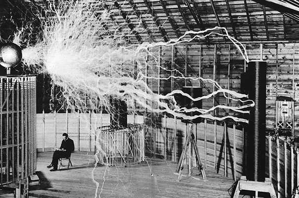 Nikola Tesla Sitting In His Laboratory With His "Magnifying Transmitter"