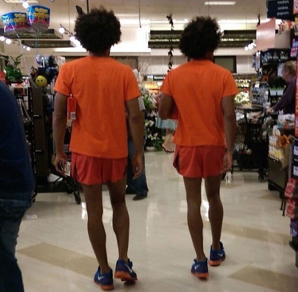 Two man walking and wearing same clothes and having same haircut