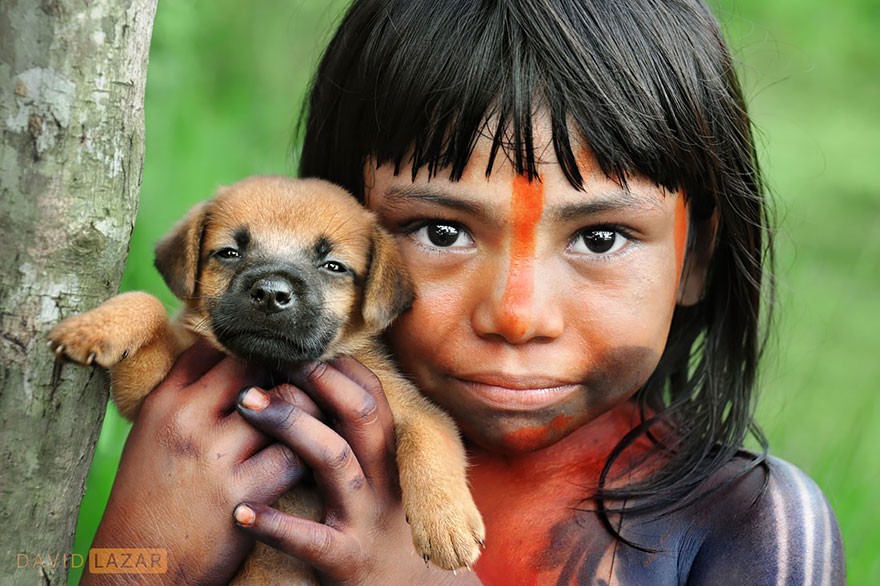 A Girl Covered In Traditional Body Paint Holds Her Puppy