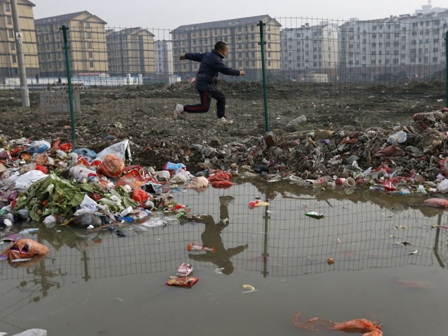 Child Jumps Over Trash At A Village, Jiaxing