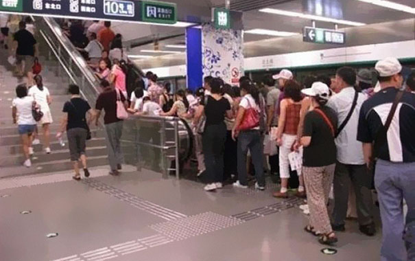 Lazy People Waiting In Line At An Escalator