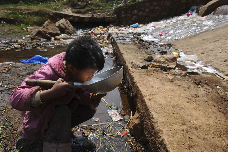 Child Drinks Water From Stream In Fuyuan County, Yunnan Province