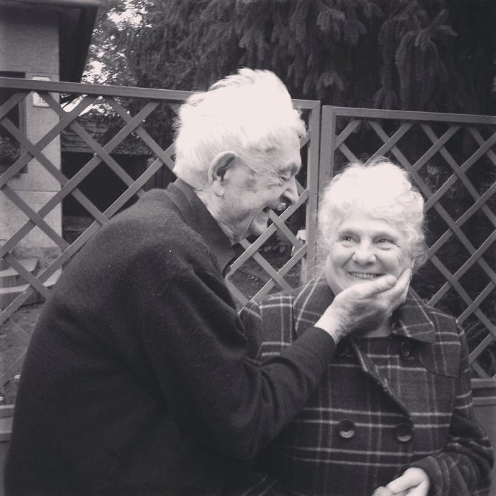 Elderly couple smiling happily, enjoying each other's company outdoors.