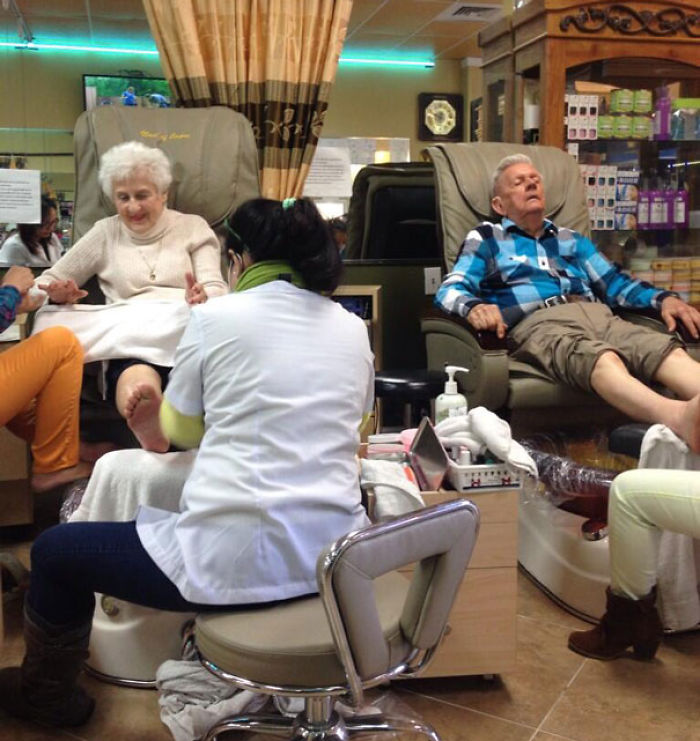Elderly couple having fun and relaxing with a pedicure at a salon, enjoying each other's company.