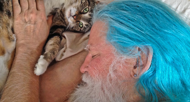 A Blue Haired Man With His Green Eyed Cat(burnell Yow!photographed By His Wife Betsy Alexander)