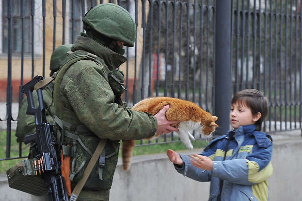 Soldier Handing Cat To Kid