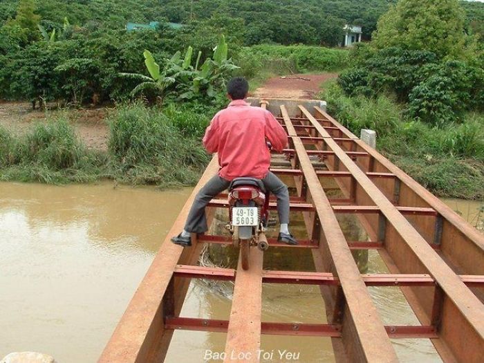 Man on a motorcycle crossing a narrow bridge, illustrating why women live longer than men.