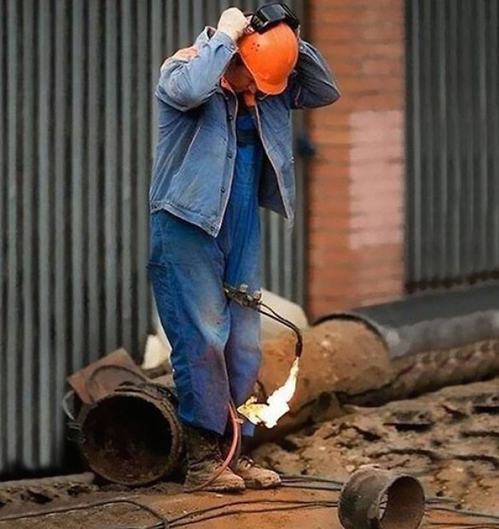 Man with a blowtorch pointed at his pants, illustrating risky behavior, contributing to reasons why women live longer than men.