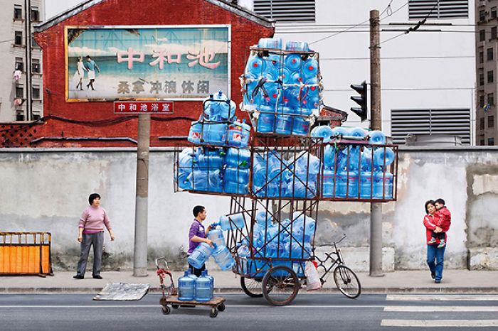 A man balancing multiple water bottles on a bike cart, illustrating why women live longer than men.