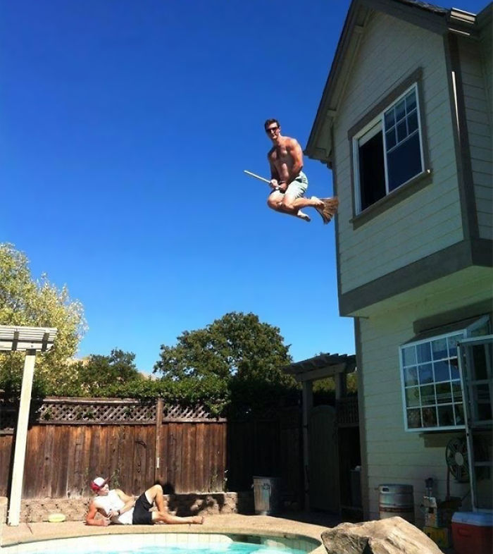 Man jumping off a roof on a broomstick over a pool, illustrating why women live longer than men.