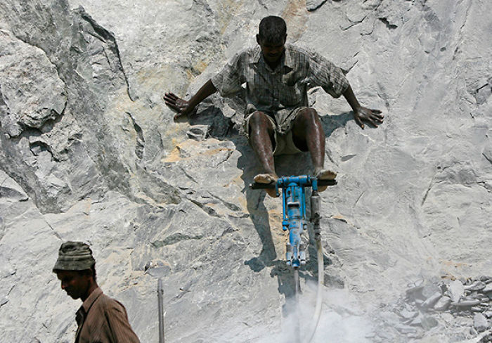 Man using heavy machinery on a rocky surface, highlighting reasons women live longer than men.