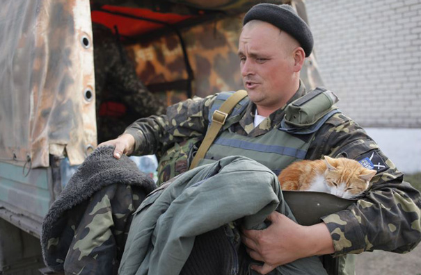 A Ukrainian Soldier Holds A Cat As He Receives Warm Clothes