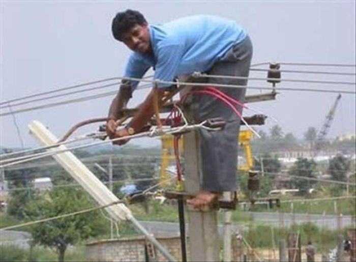 Man performing a risky electrical repair on a pole, illustrating why women may live longer than men.