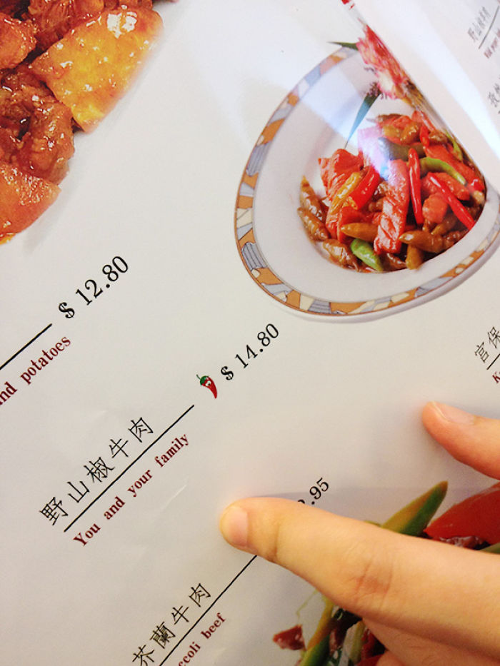 Menu translation fail with dish listed as "You and your family" priced at $14.80, humorous mistake highlighted by a finger.