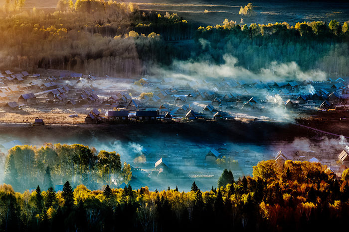 Scenic village in China with morning mist and colorful autumn trees showcasing reasons to visit China.