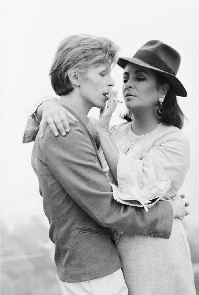 Singer David Bowie Sharing A Cigarette With Actress Elizabeth Taylor In Beverly Hills (1975)