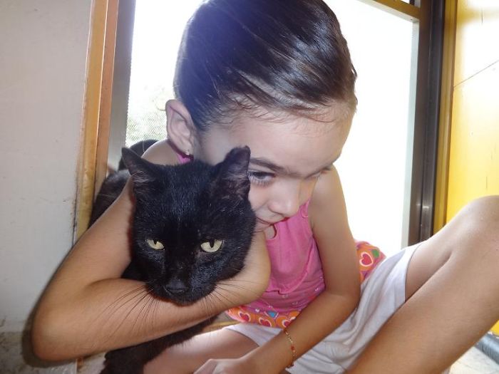 My Daughter With The Neighborhood Cat Who Never Let Anyone Touch Him Before.