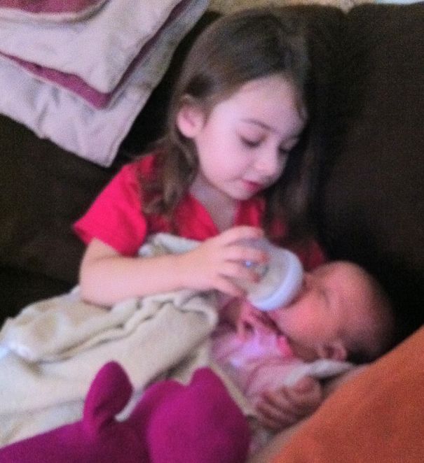 My 3-year Old Daughter Feeding Her Newborn Sister.