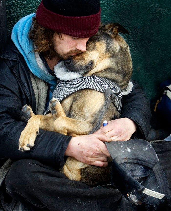 Homeless Man Sleeps In The Arms Of His Dog