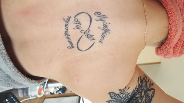 Lettering and infinity tattoo on back