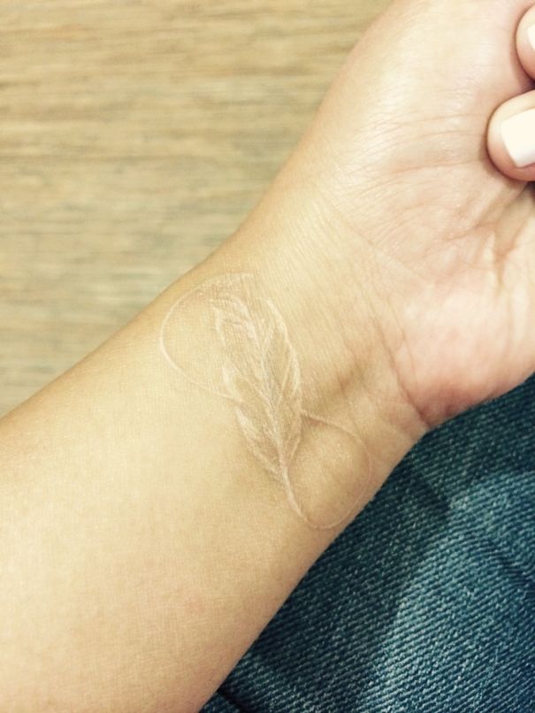 Eternity and feather white tattoo on wrist