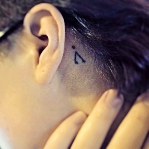 Tauri symbol behind ear tattoo