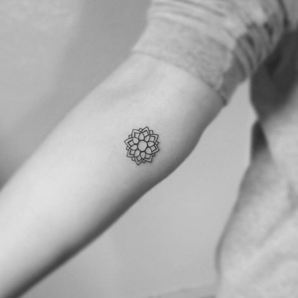 Black, linear minimal mandala tattoo on arm