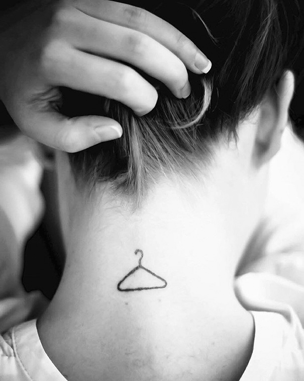 Simple coat hanger tattoo on woman's back neck