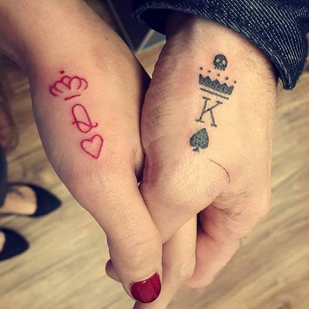 Red queen and black king tattoos on couple hands