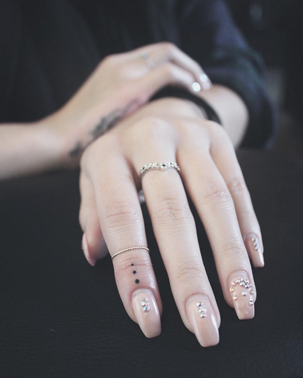 Small three-dot tattoo on the finger