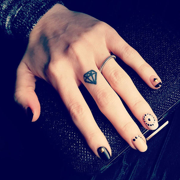 Black diamond tattoo on the middle finger