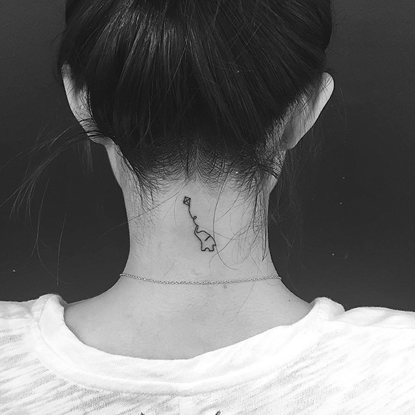 Minimal elephant and kite tattoo on back neck