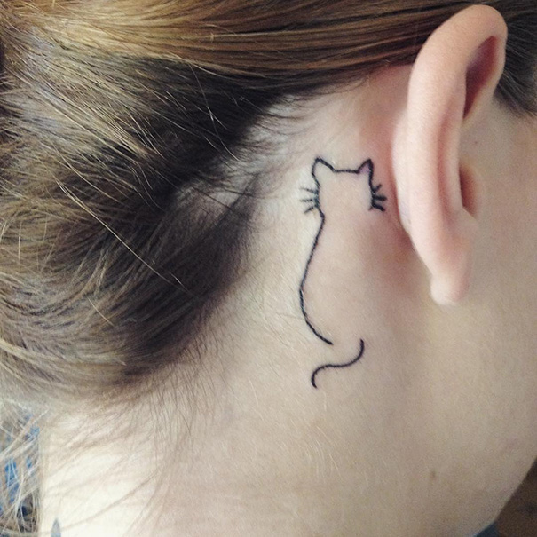 Linear cat tattoo behind the ear