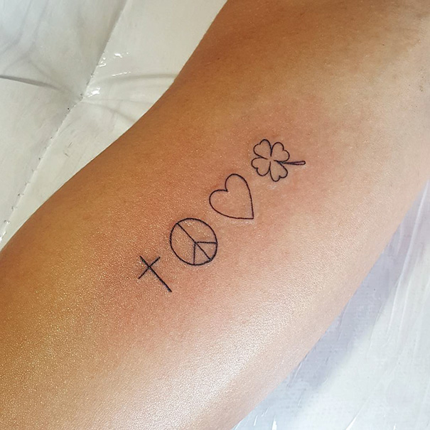 Linear minimal cross, peace symbol, heart, and clover tattoo