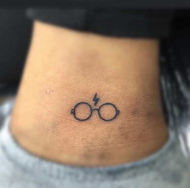 Harry Potter glasses and a lightning bolt tattoo on leg