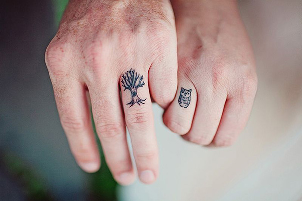 Black small tree and owl tattoos on couple fingers