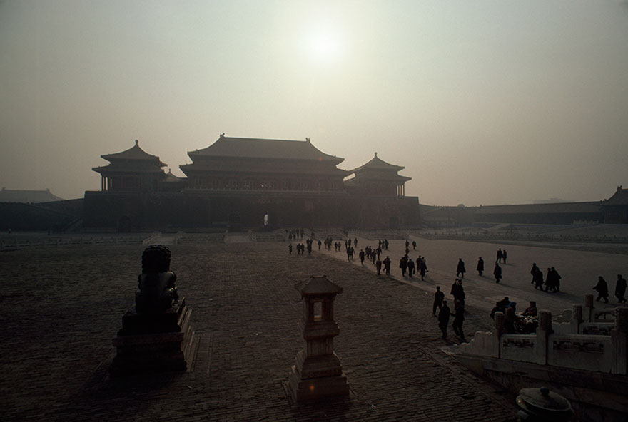 The Huge Gate Of Heavenly Peace, The Main Entrance To The Forbidden City In Beijing, Looms In The Dusty Early Morning Haze Which Partially Obscures The Sun. This View, Taken From Tiananmen Square, Shows The Tiny Figures Of People Walking Along The Main Thoroughfare Leading To The Gate, 1978