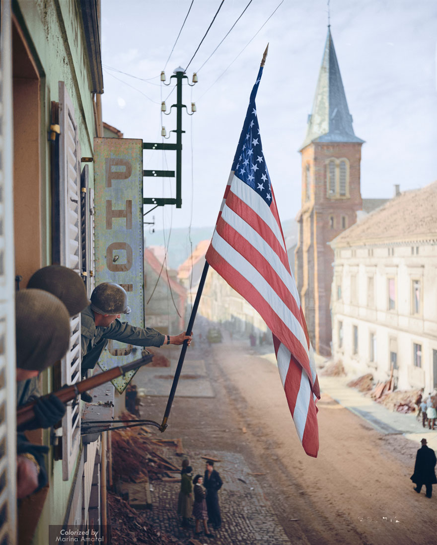 Captain Thomas H. Garahan Raises The 'stars And Stripes' Flag Made Secretly By A Local French Girl, 1945.