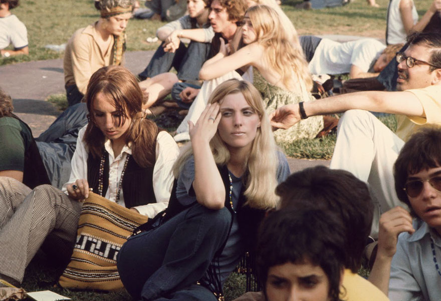 Women Sit On The Grass And Wait For A Bus To Take Them To The Woodstock Music And Arts Fair