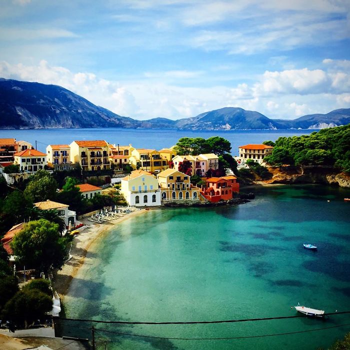 Colorful seaside village by the water with mountains in the background, embodying a fairy tale feel.
