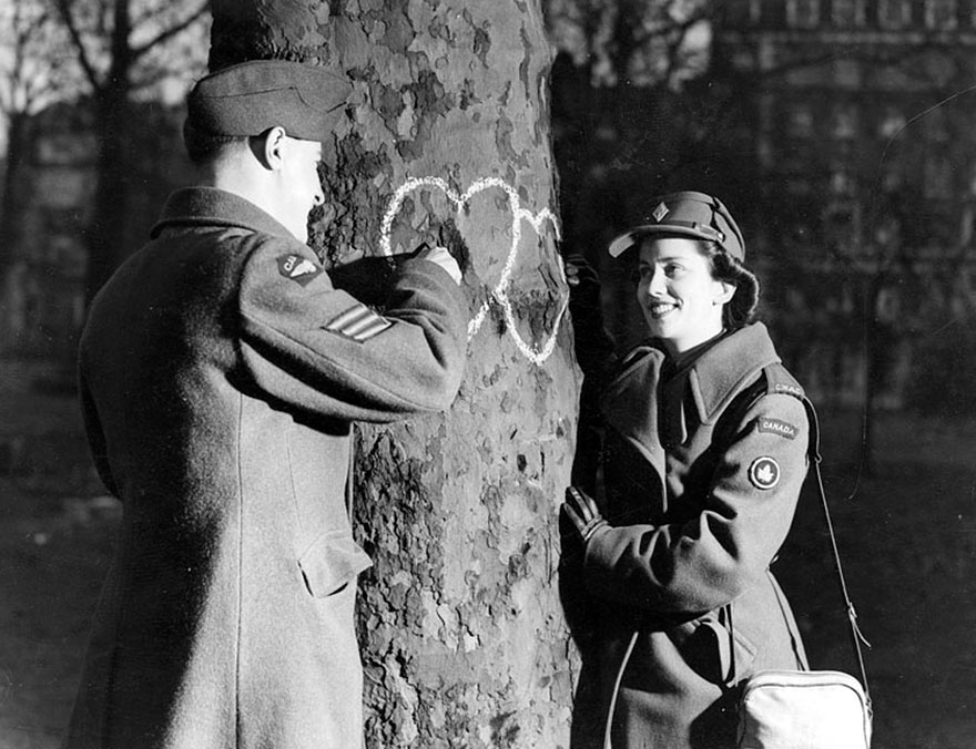 Young Couple Chalking Hearts Onto A Tree, Valentine's Day, 1944